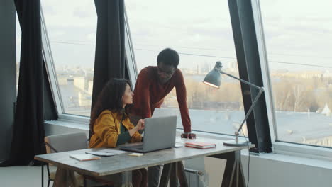 diverse coworkers discussing document in modern office
