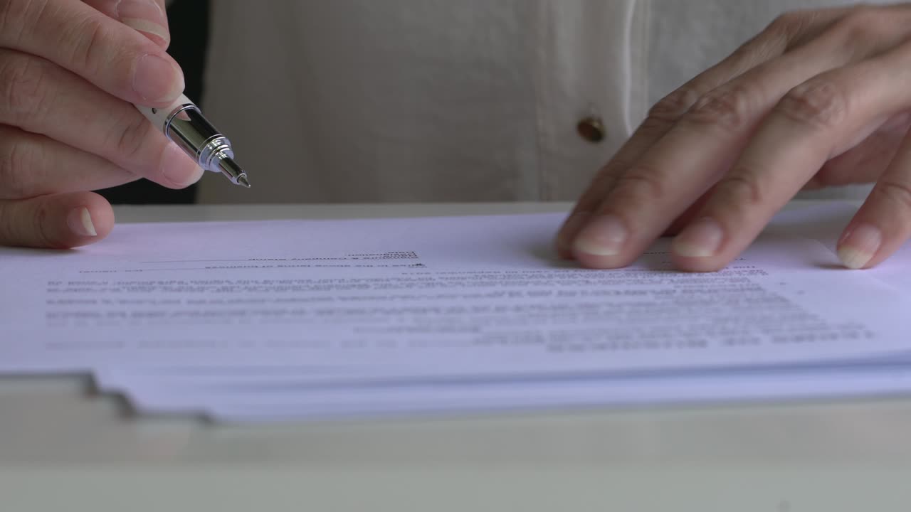 vista de cerca de una mujer de negocios firmando un documento de contrato.