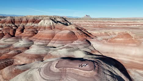 aerial view of three people on bentonite hills, scenic landscape in desert of utah usa