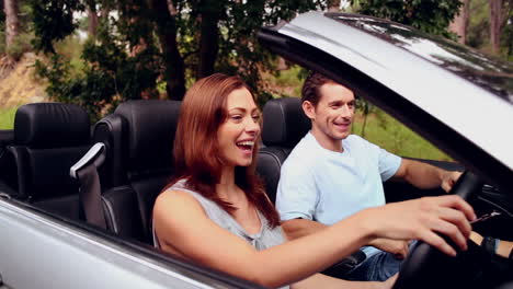 Happy-couple-looking-at-a-map-in-a-convertible