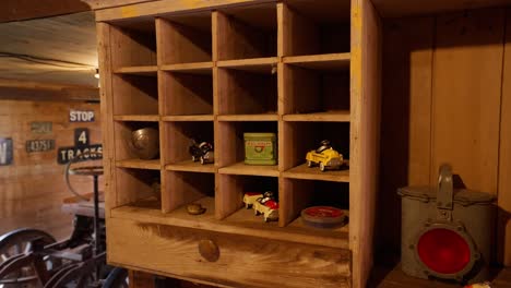 antique toy cars and other objects on the shelves inside of an old wooden barn