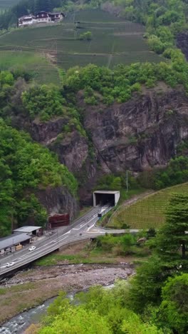 vertical shot of a tunnel entrance in south tyrol, italy, with vineyards and alpine terrain around