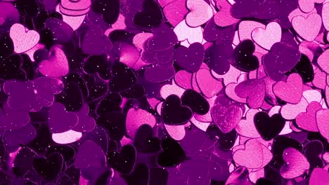 Animation-of-snow-falling-over-glowing-purple-hearts