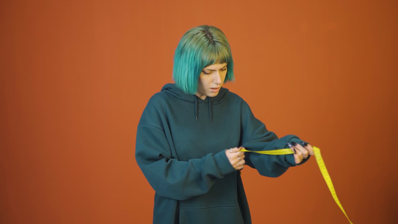 자신의 체중에 불만을 품고 있는 젊은 여성.