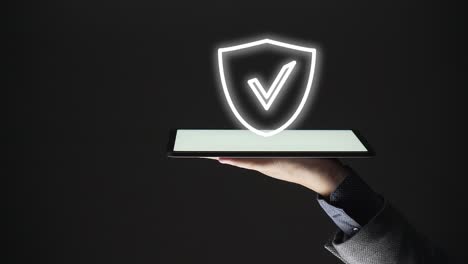 hombre de negocios muestra un escudo con un icono de marca de verificación en una tableta