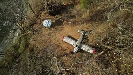 abandoned small airplane stuck on the top of a hill by the coast in costa rica, province of guanacaste 4k aerial drone from above pan up