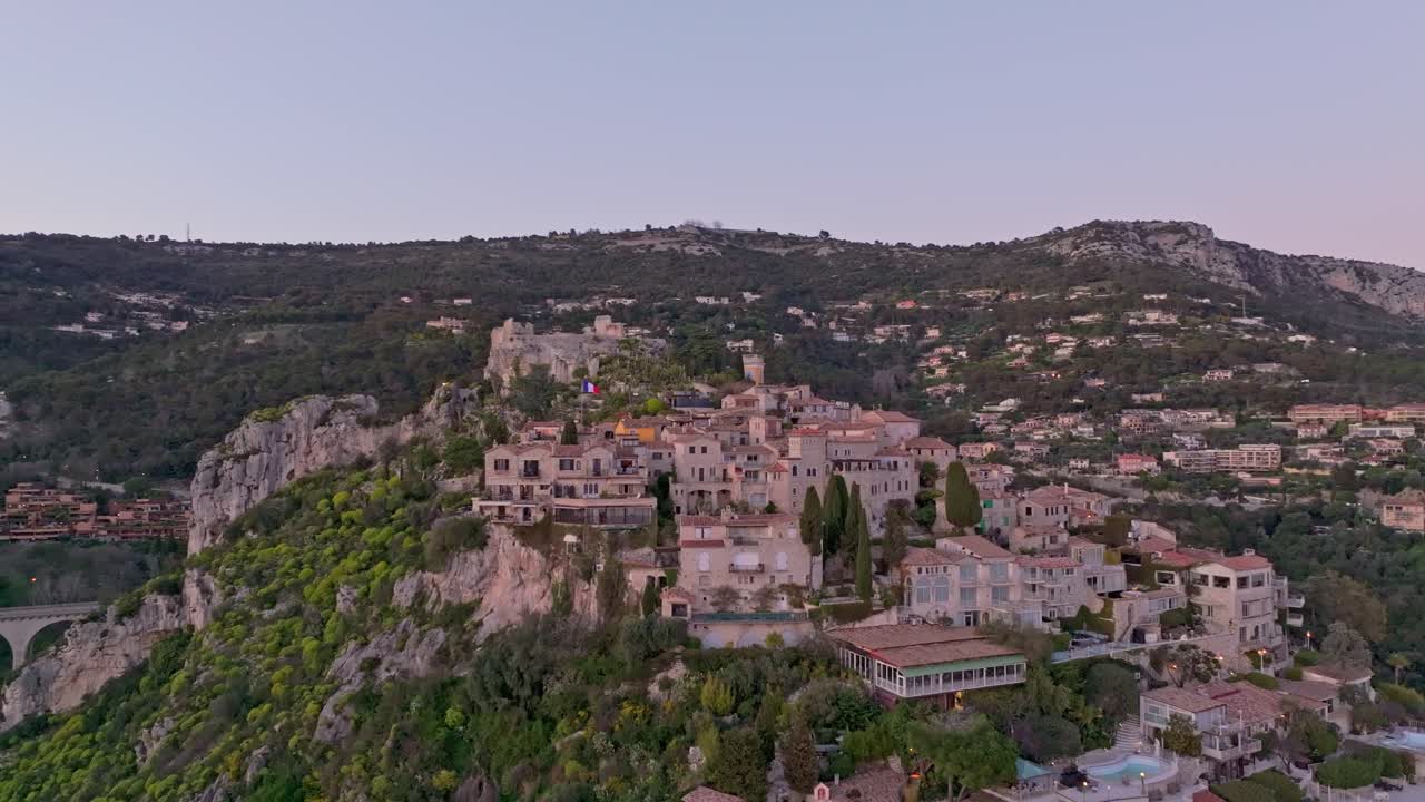 フランス、コートダジュール地方の歴史的な丘の上の村エズが夕暮れ時に輝く空撮。
