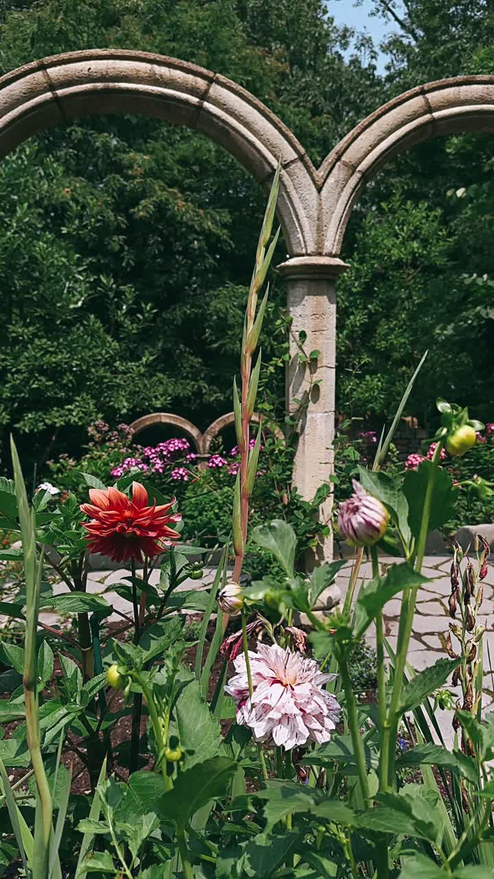 hermoso jardín de flores con arcos de piedra