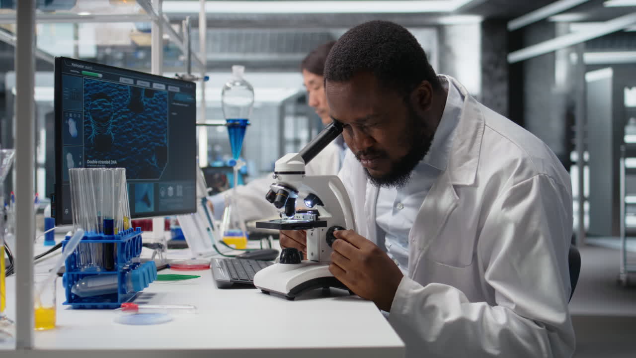 Vertical video Clinical microbiologist in lab using microscope for pathology research
