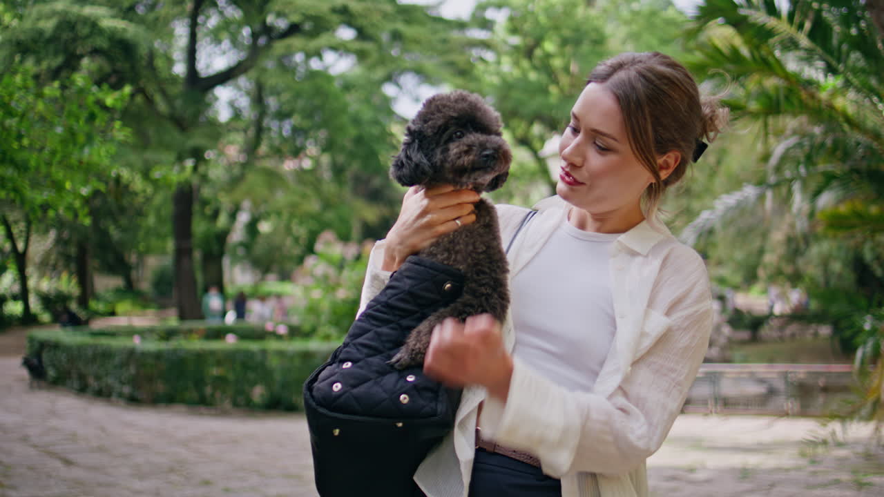 Playful woman hugging dog walking green park closeup. Happy girl caressing pet