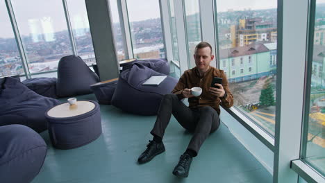 handsome man talking on mobile phone and drinking coffee