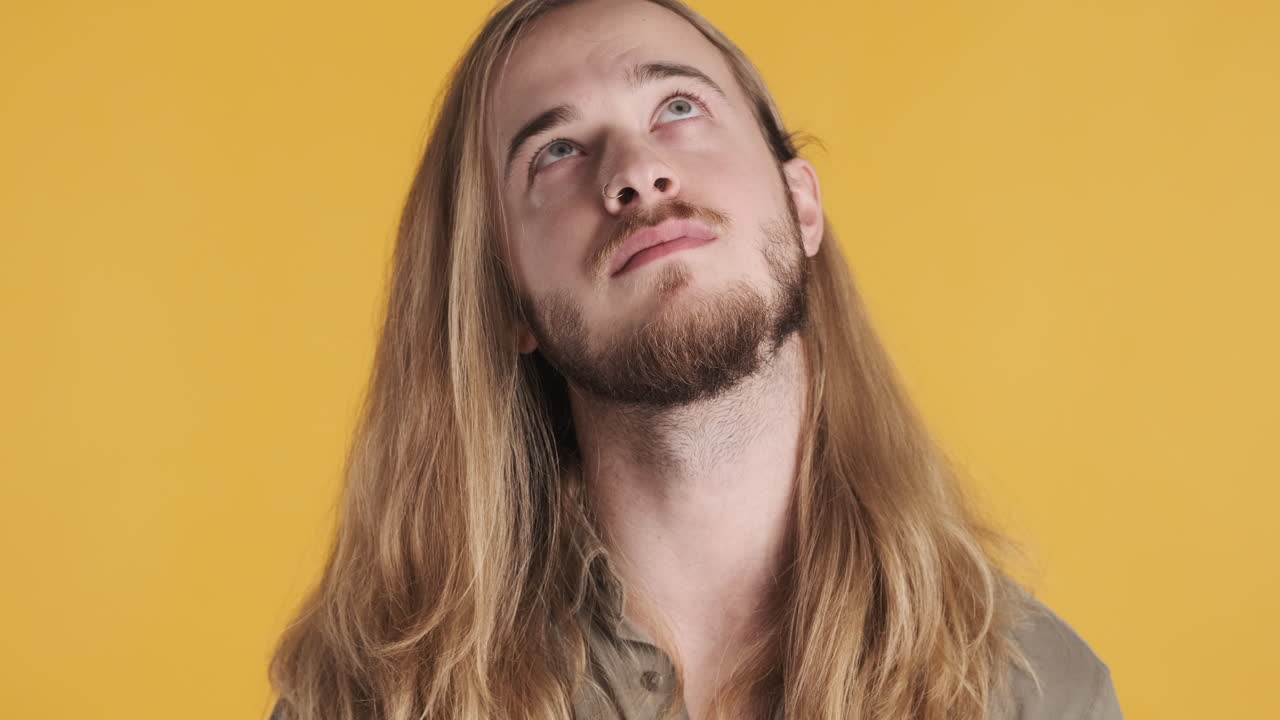 un joven caucásico aburrido mirando a la cámara.