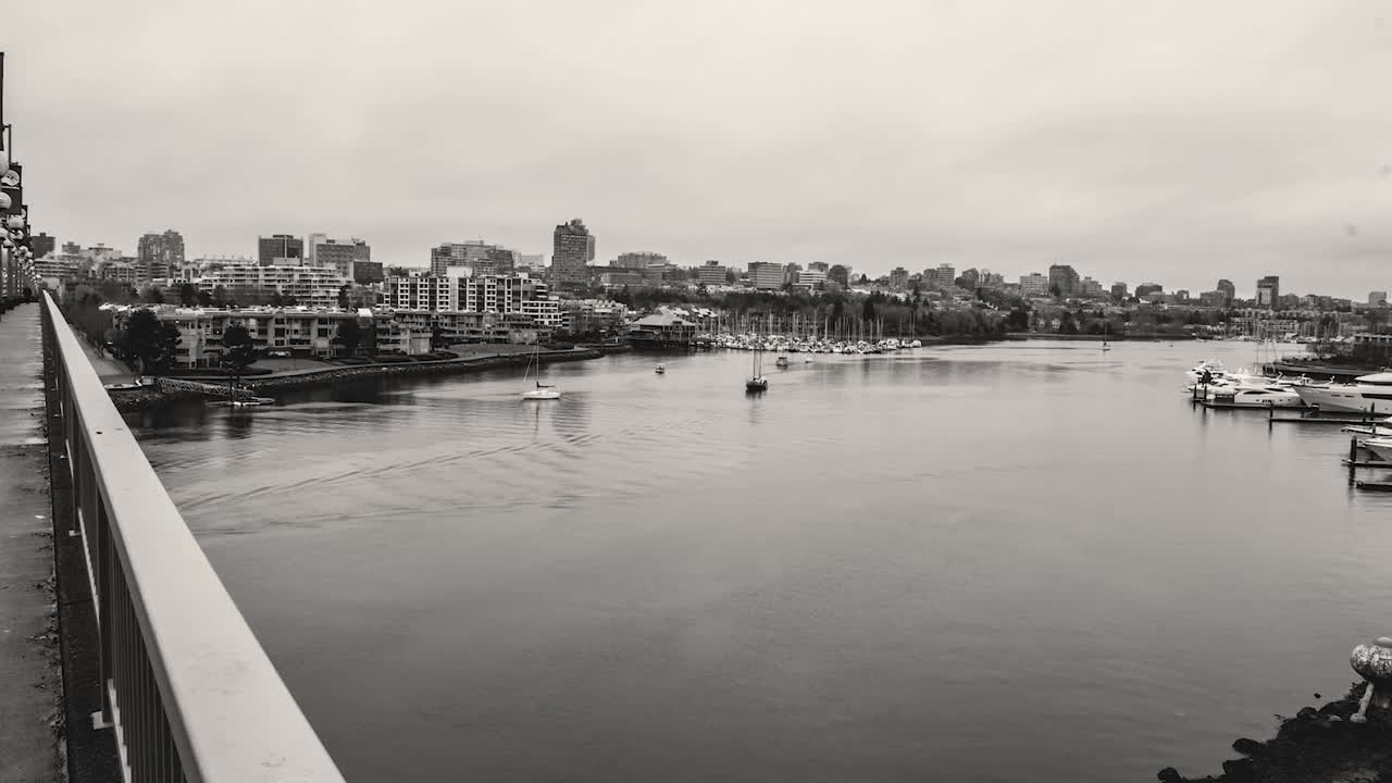 구름 위를 지나가는 다리 아래 바다 입구를 통해 반사 물 위를 항해하는 보트의 시간 경과