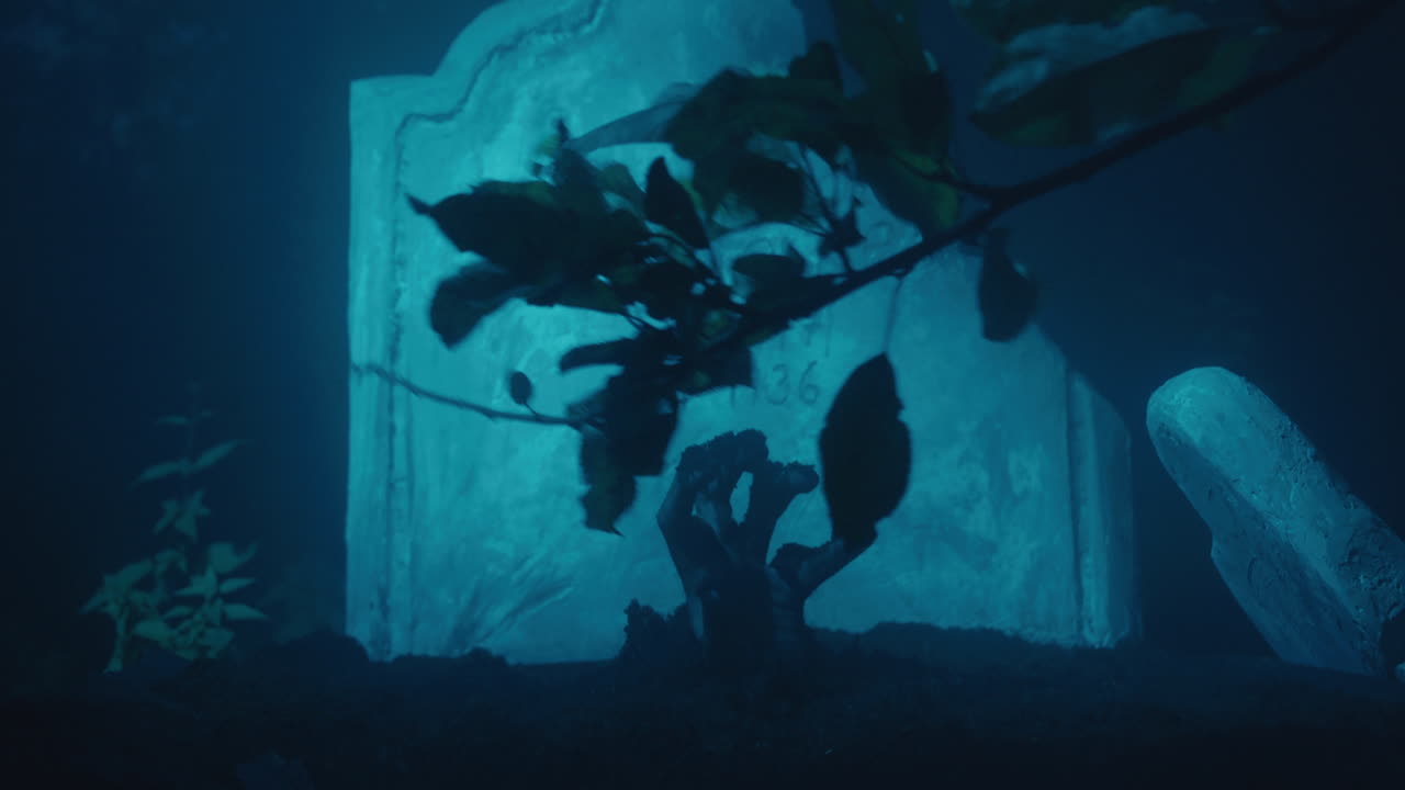 mano muerta viviente levantándose de la tumba, lápida a la luz de la luna, sombras y ramas, atmósfera de halloween