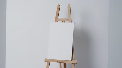 Video-of-white-canvas-sign-on-wooden-easel-with-copy-space-on-white-background