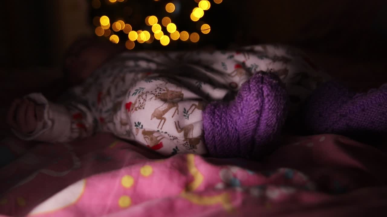 누워서 어둠 속에서 움직이는 신생아