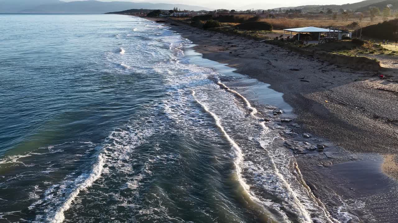 Vista aerea di onde dell'oceano che si infrangono su una spiaggia sabbiosa all'alba a Corfù, Grecia. Paesaggio costiero sereno con acqua turchese