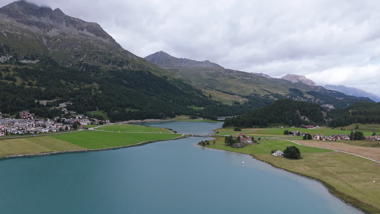 Serene lake near Silvaplana with mountains, clouds, and tranquil scenery