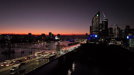 Static-aerial-shot-of-Brisbane-City-at-sunset-with-Expressway-Motorway,-Brisbane-River-and-bridges-in-shot