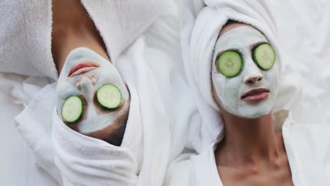 video de relajadas amigas diversas hidratándose con máscaras faciales y pepinos