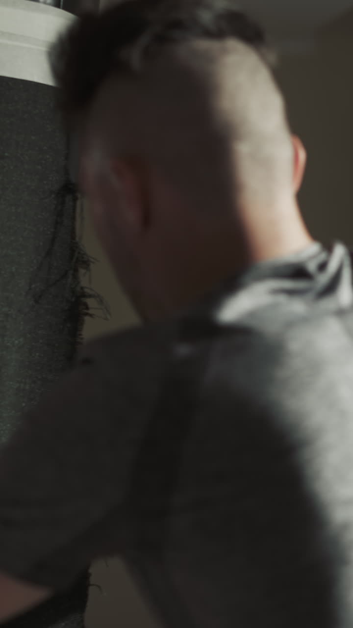 el boxeador golpea la bolsa de boxeo con las manos en guantes en el club deportivo. el deportista entrena golpeando inventario especial en el gimnasio de lucha en cámara lenta. artes de combate