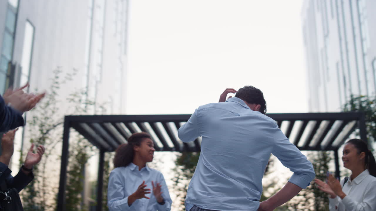 오피스 빌딩의 팀 리더가 박수를 치고 행복한 직원들이 직원을 칭찬합니다.