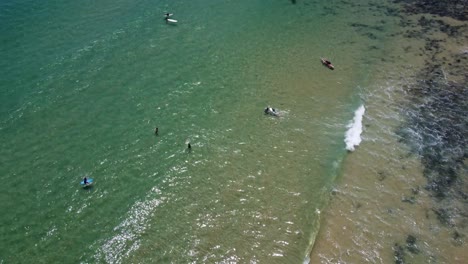 Surfers-trying-to-catch-a-wave-on-a-hidden-beach