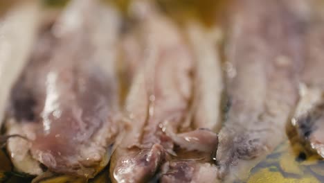 fresh sea sardines and anchovy fish and mullus on display on ice on market store shop. seafood fish background, close up stand of small salty white fish.