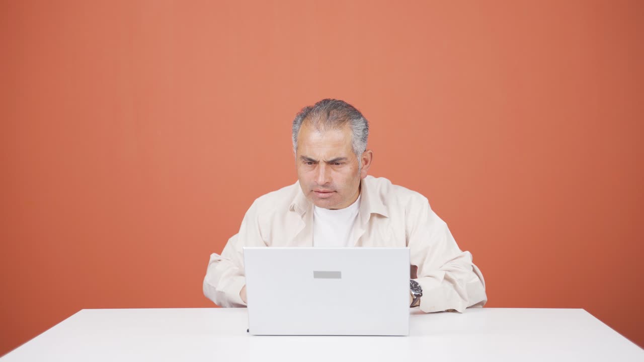 hombre concentrado trabajando en una computadora portátil.