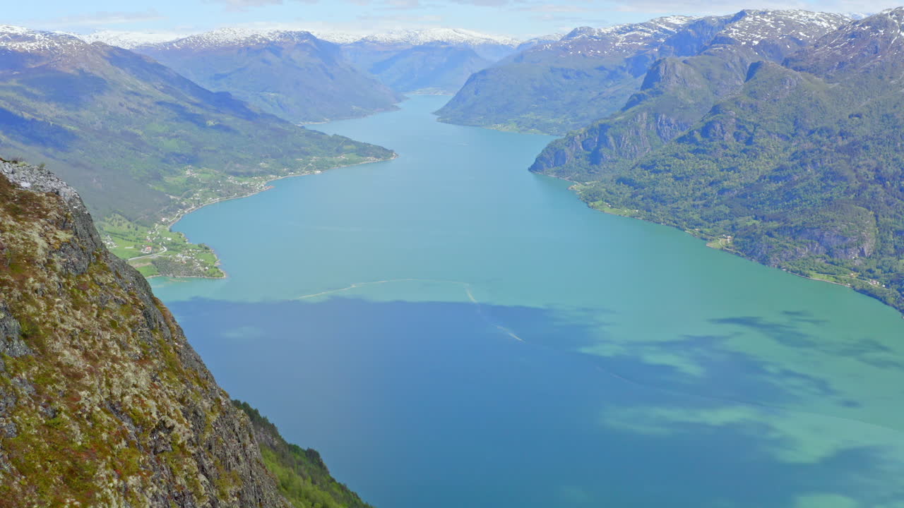 Majestic aerial view of Sogndal, Norway with the Sognefjord, lush mountains, and Sogndal Bridge under clear skies. Breathtaking Nordic landscape in soft natural light