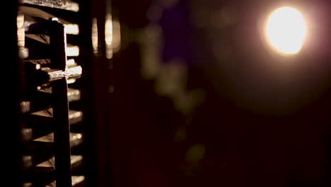 A-small-wooden-cross-hangs-in-the-church-with-lighting-on-it---camera-moving-left