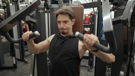 Fit-Mature-Man-in-40s-workout-in-Hammer-strength-machine