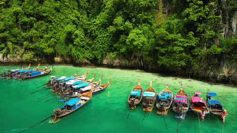 coloridos barcos turísticos amarrados en la majestuosa laguna de las islas phi phi