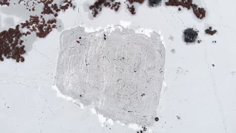 people chaotically skating on the freezed ice lake top drone view