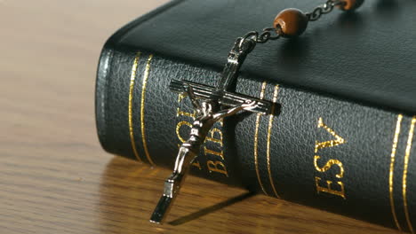 rosary beads falling onto black bible