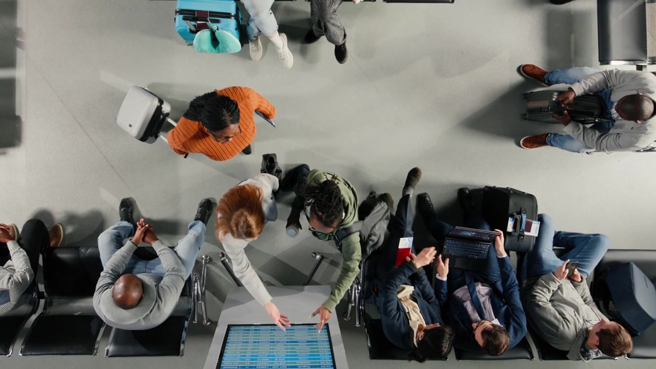 Friends in airport checking departure board for timetable, traveling together
