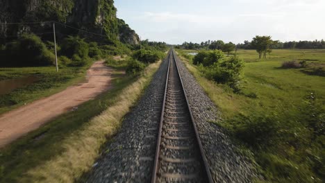 vía ferroviaria de vía estrecha recta viaja a un punto perspectiva en el horizonte, avión no tripulado volar sobre él el campo de camboya, se asia