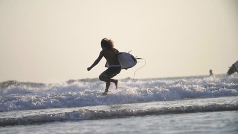 surfer running into the ocean