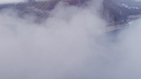 Drohne-Fliegt-Bei-Sonnenaufgang-Durch-Wolken-Am-Piva-Lake-Canyon-In-Montenegro,-Luftaufnahme