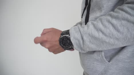 young man putting on sports watch to go out on a date