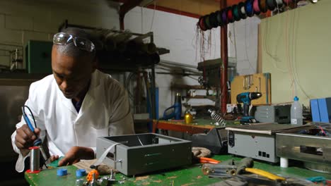 trabajador masculino que usa un soldador en una fábrica de vidrio 4k