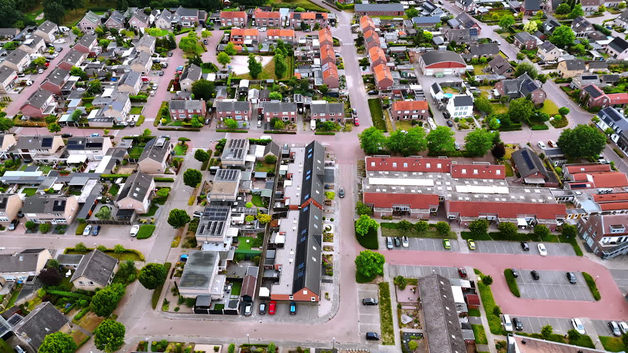 Summer in a suburban area. Aerial view of a quiet residential area with homes, green spaces, and well-maintained streets on a sunny day