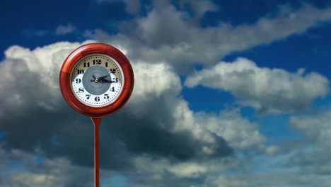 red clock and space for design against floating clouds