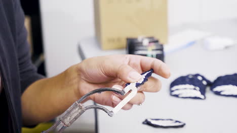 trabajadora que utiliza una herramienta caliente para insignias de borde