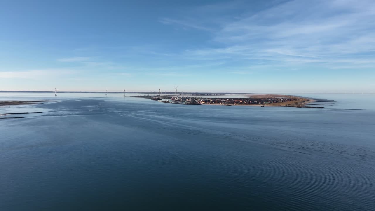 A panoramic drone view captures the coastal town of Thyborøn in western Denmark, showcasing its harbor, buildings, and surrounding North Sea landscape from above in stunning detail.
