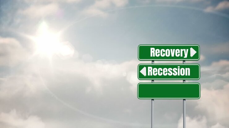 Ordene "Opsving" og "Recession" skrevet på vejskilte på en blå himmel i baggrunden.