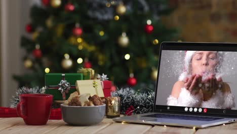 Happy-caucasian-woman-in-santa-costume-on-video-call-on-laptop,-with-christmas-decorations-and-tree