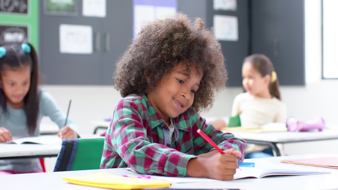 In school, child writing in notebook in classroom, focusing on work