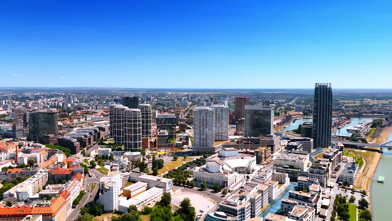 Panorama of the sunny cityscape of Bratislava, Slovakia. Spectacular top view of the city at the backdrop of blue clear sky.