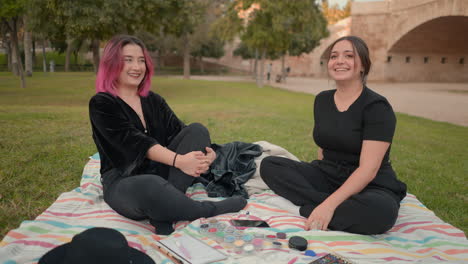dos mujeres disfrutando de un picnic en el parque